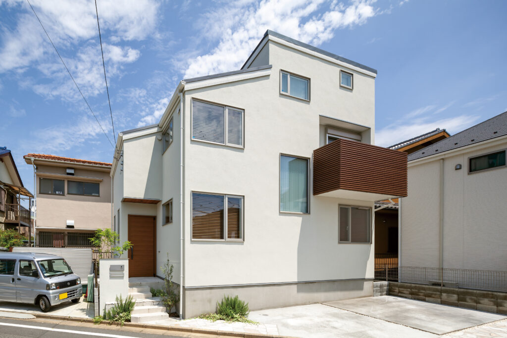 白い塗り壁と木目バルコニー