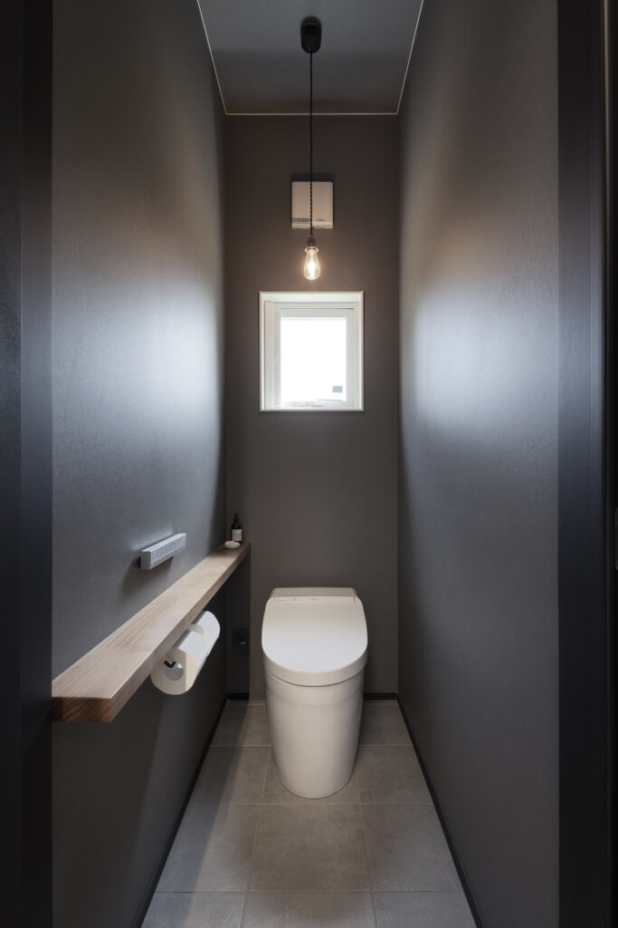 造作棚のあるグレー色の壁のトイレ